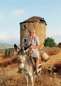Großmutter Madeleine auf ihrem Esel vor einem alten Turm